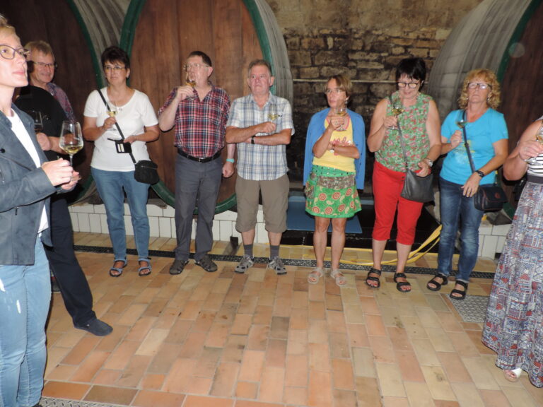 Weinprobe der Weinbruderschaft vor großen Holzfässern im Gewölbekeller